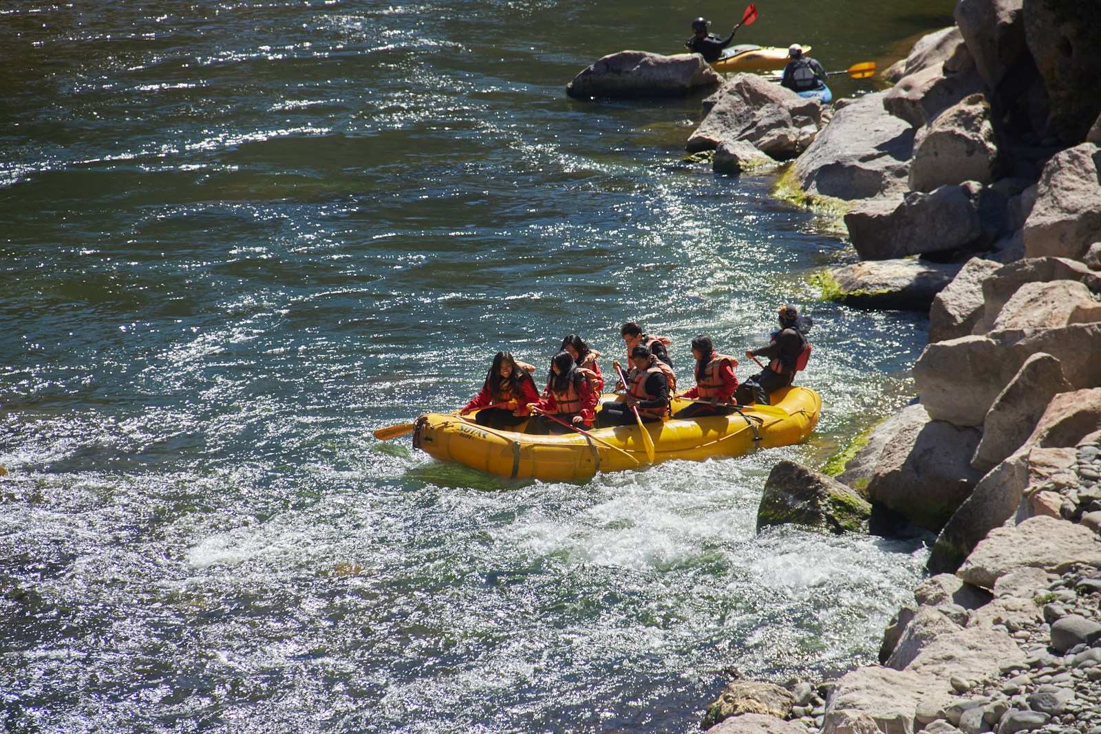 a group of people in a yellow canoe on a river